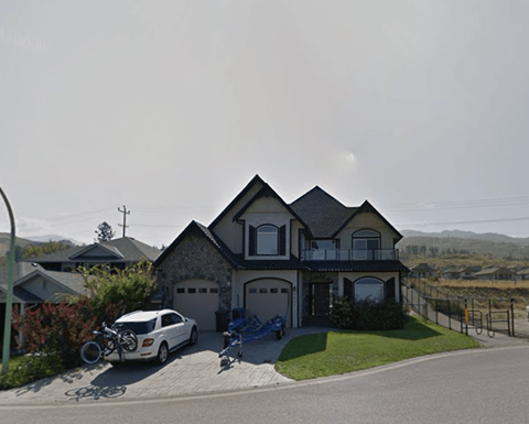 A house with a white car parked in front.