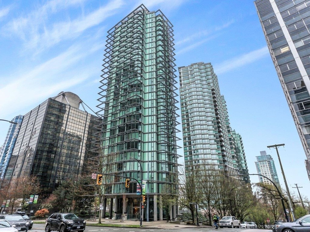 A modern glass building stands tall in a city street.