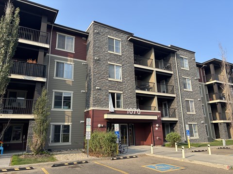 The image shows a multi-story apartment building with the number 1070 on the front.