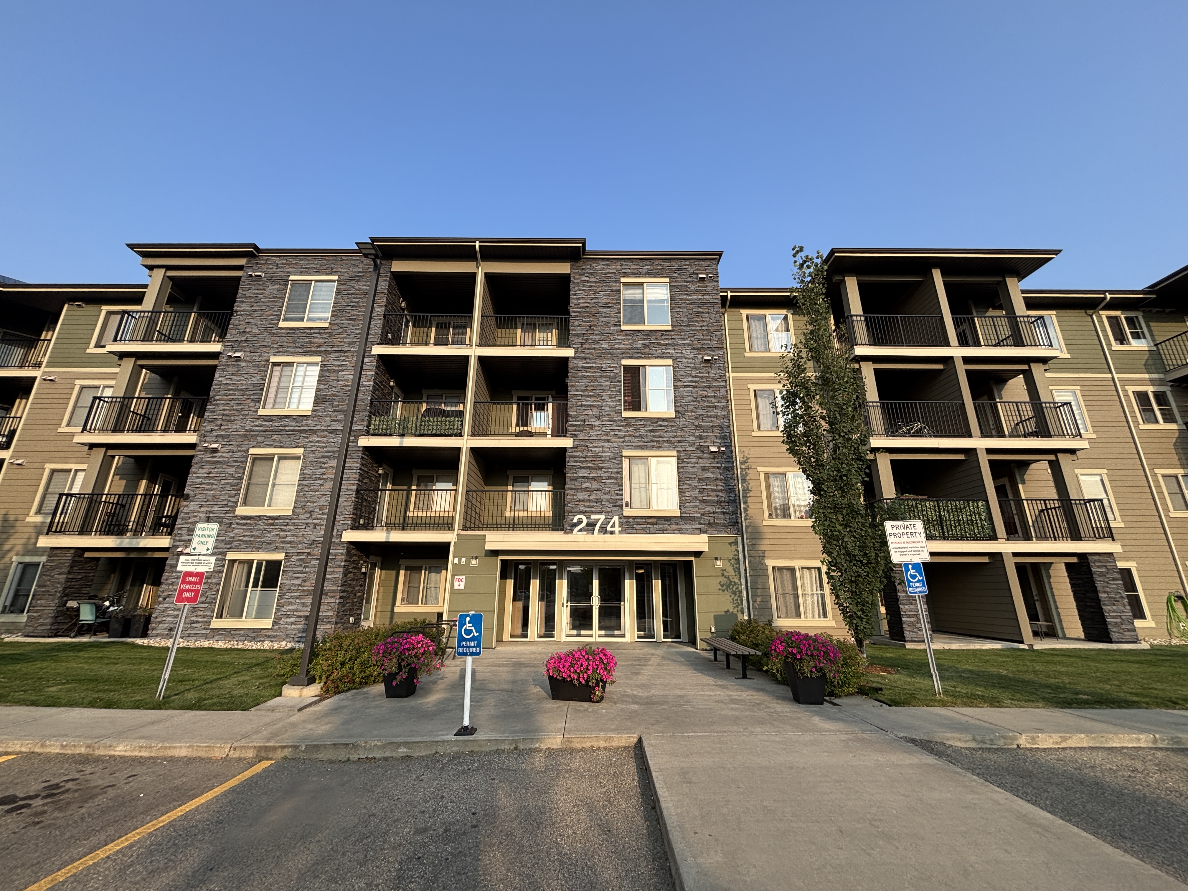 Apartment building with a blue sign in front.