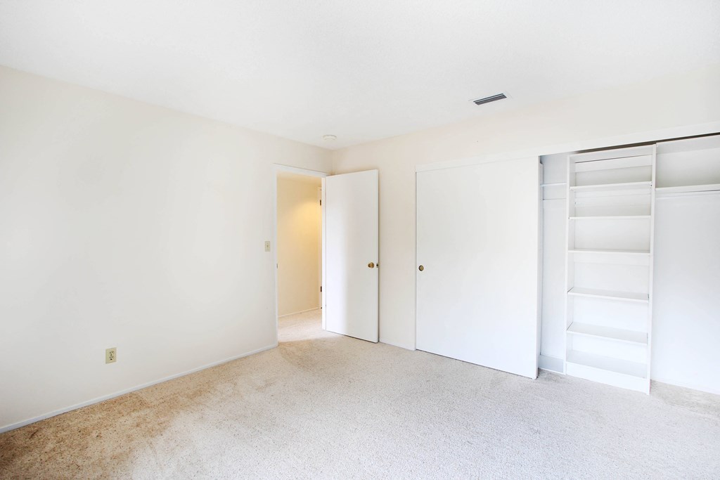 a bedroom with white walls and carpet