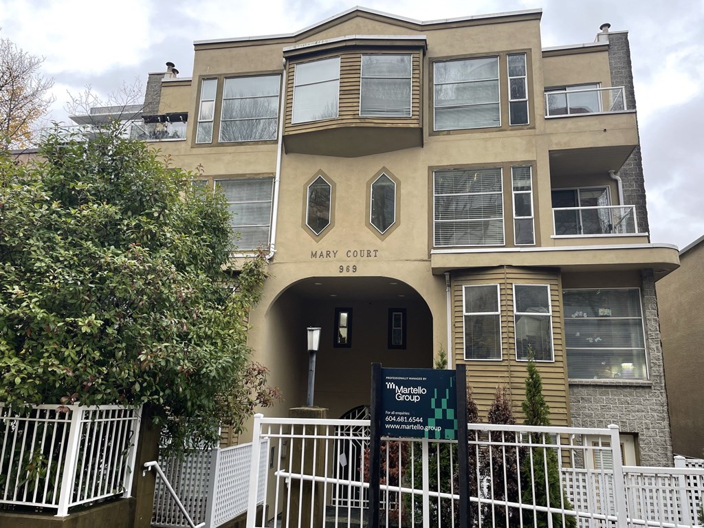 The Mary Court building is a multi-story residential building with a white fence in front.