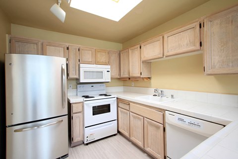 a kitchen with white appliances and wooden cabinets