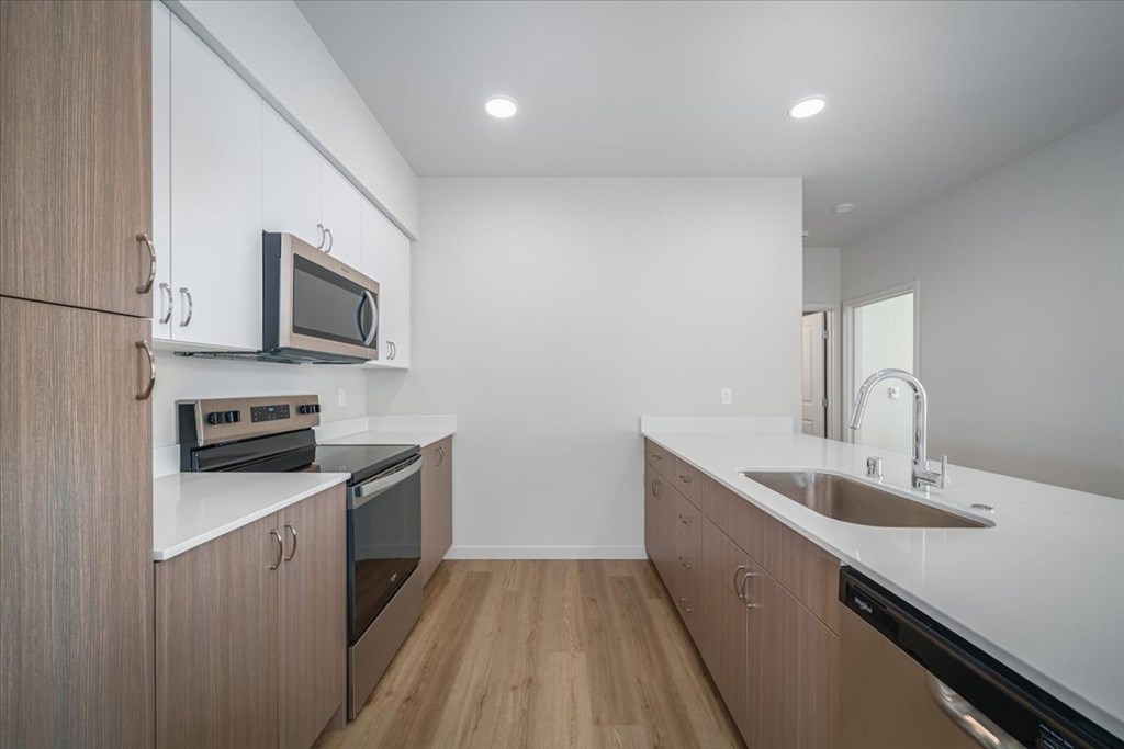 A modern kitchen with wooden cabinets and stainless steel appliances.