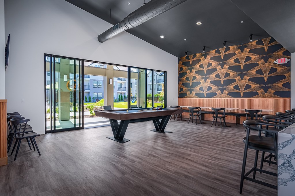 A modern dining room with a long table and chairs.