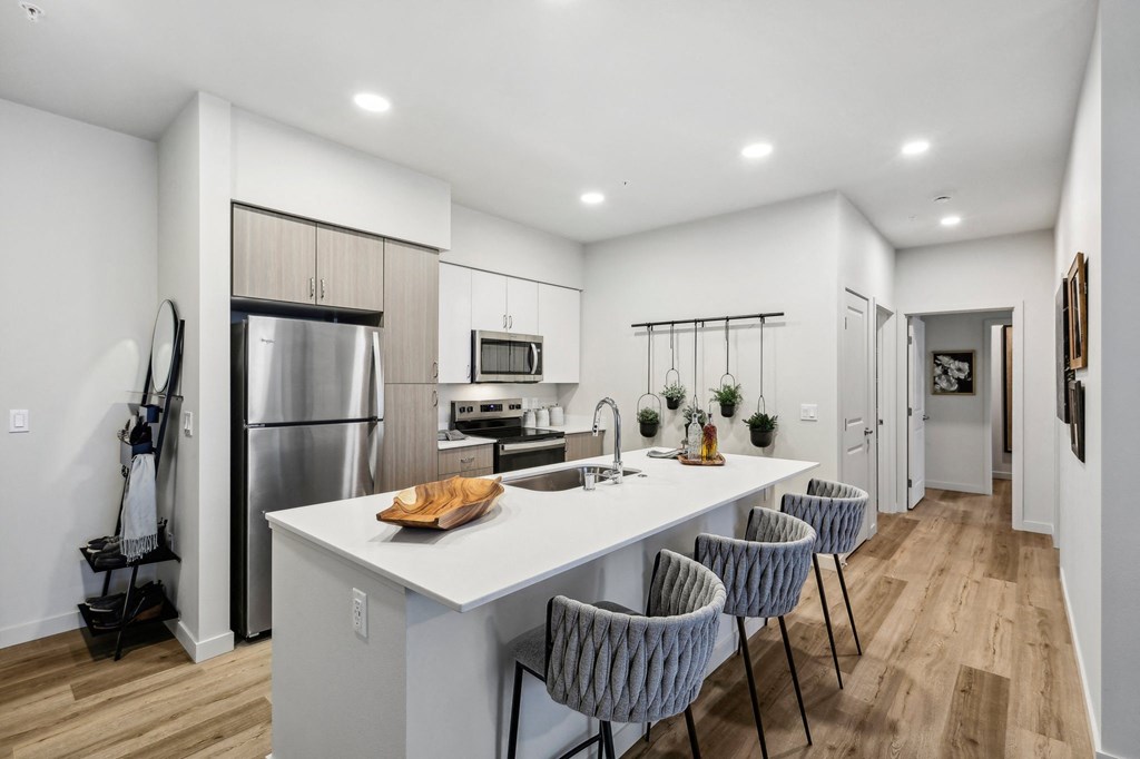 an open kitchen with a large island with four chairs