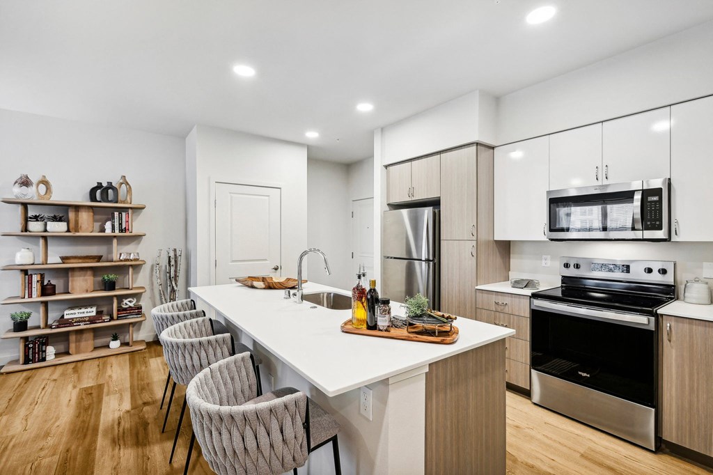 a kitchen with a large island and a stove and a refrigerator