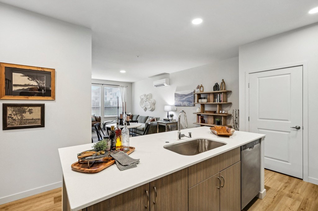 an open kitchen and living room with a sink and a window