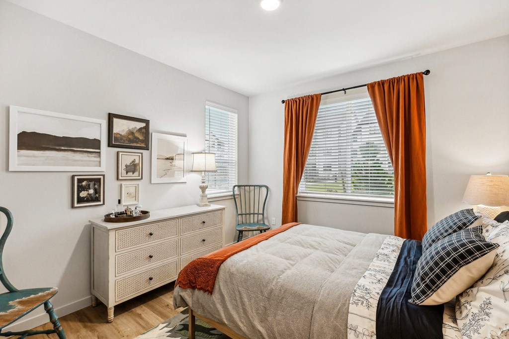 a bedroom with a bed and a dresser and a window