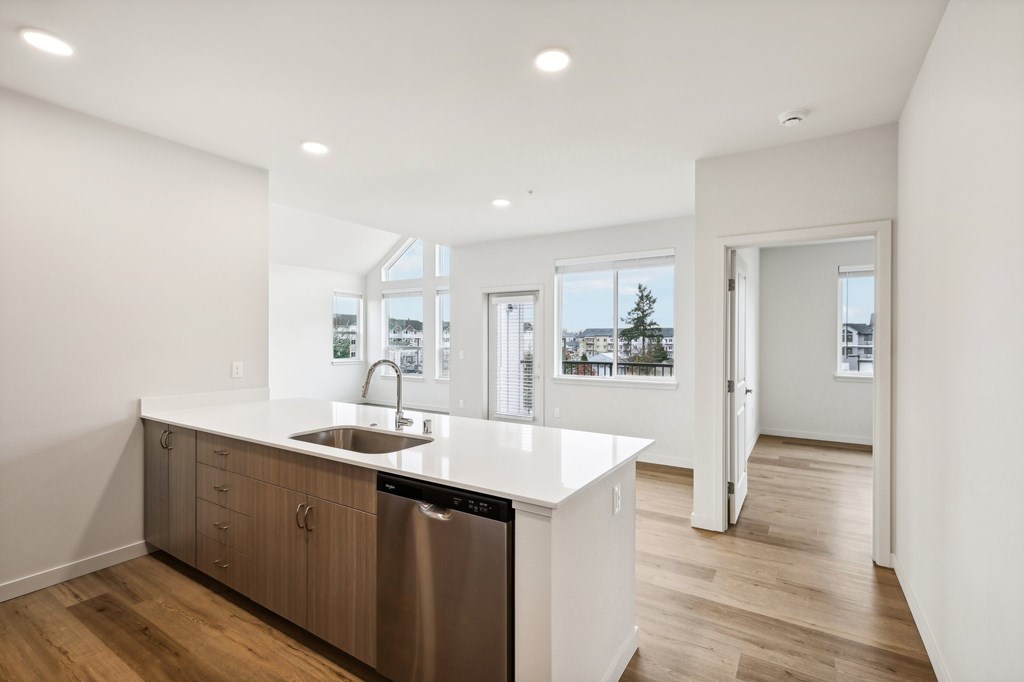 A modern kitchen with a stainless steel dishwasher and a white countertop.