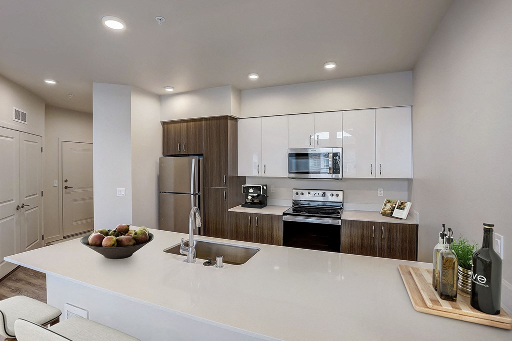 A modern kitchen with a large island and stainless steel appliances.