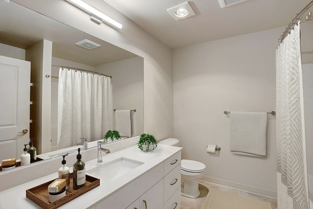 A bathroom with a white sink and a white toilet.