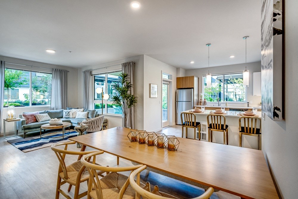 a living room and dining room with a wooden table and chairs