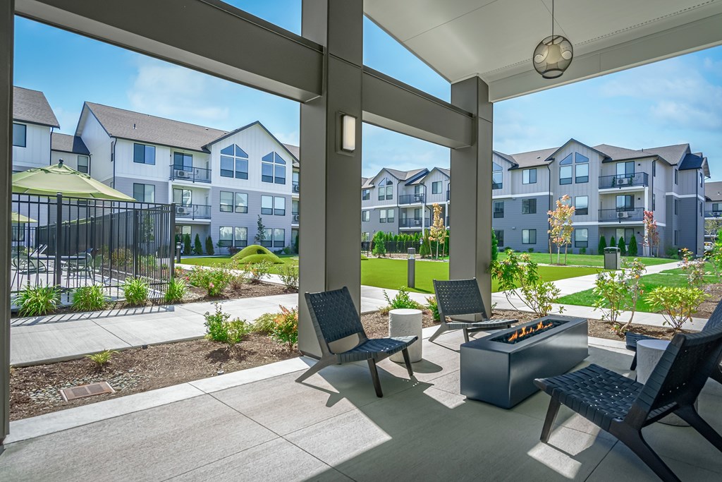 A patio with a table and chairs overlooks apartment buildings.