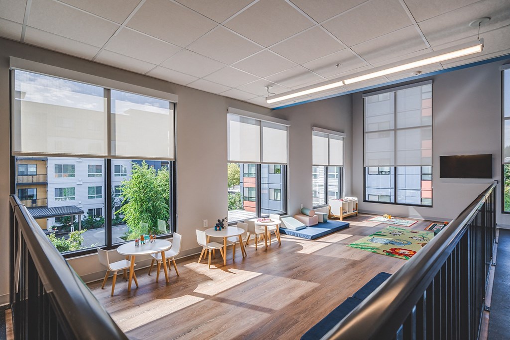 a large living room with tables and chairs and large windows