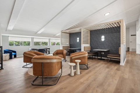a living room with chairs and a table and a wall with a fireplace