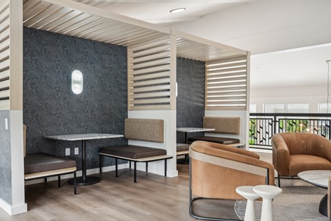 a lobby with chairs and tables and a staircase