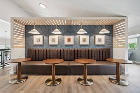 a seating area with stools and a wall with pictures