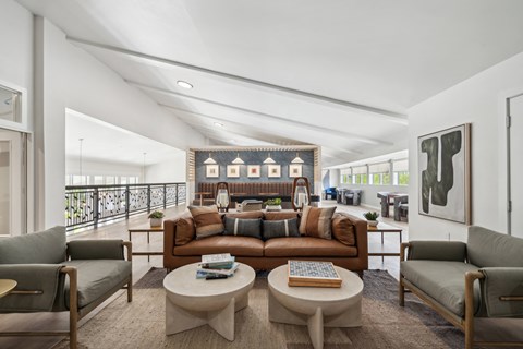 a living room with couches and tables and a balcony