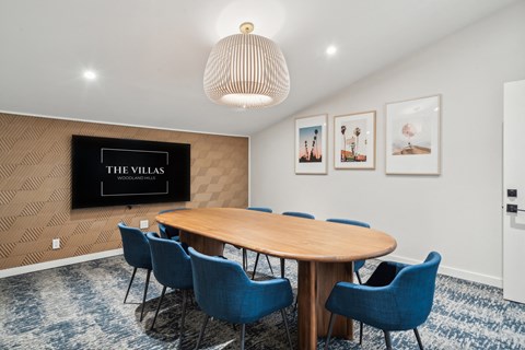 a conference room with a large wooden table and blue chairs