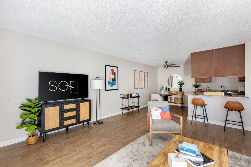 A living room with a blackboard on the wall and a wooden floor.