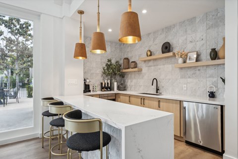 a kitchen with an island and stools in front of a window