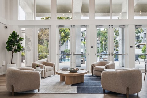 a living room filled with chairs and a table