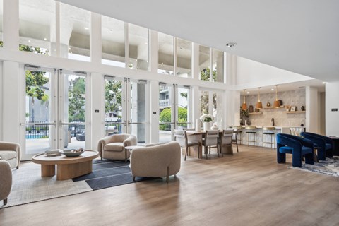 the living room and dining area of a house with floor to ceiling windows