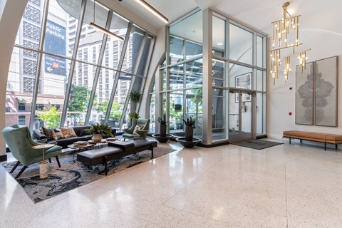 A spacious lobby with a green chair and a black coffee table.