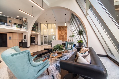 A living room with a black couch and a green chair.