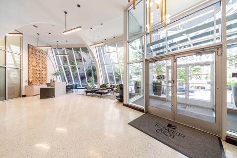 A large glass door with a sign that says "Tower 801" on the mat in front of it.