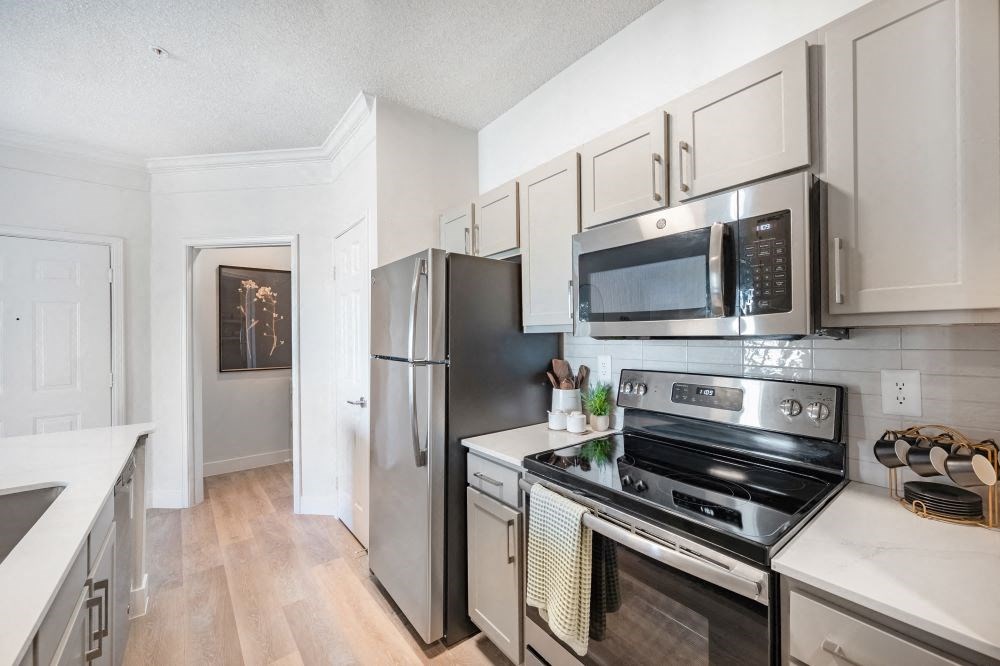 A kitchen with a stove, oven, refrigerator, and microwave.