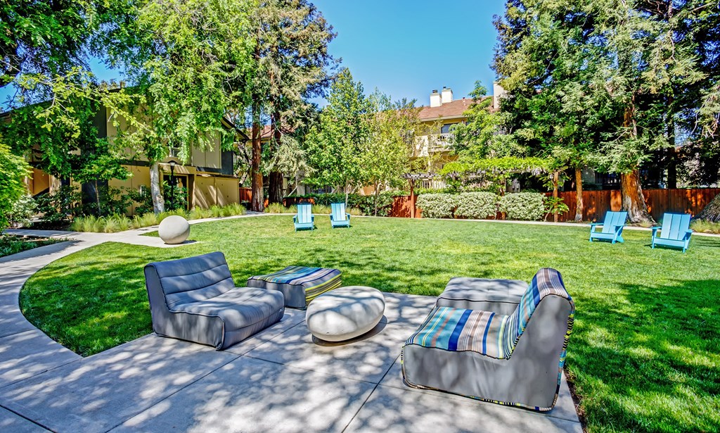 a backyard with couches and chairs and a lawn