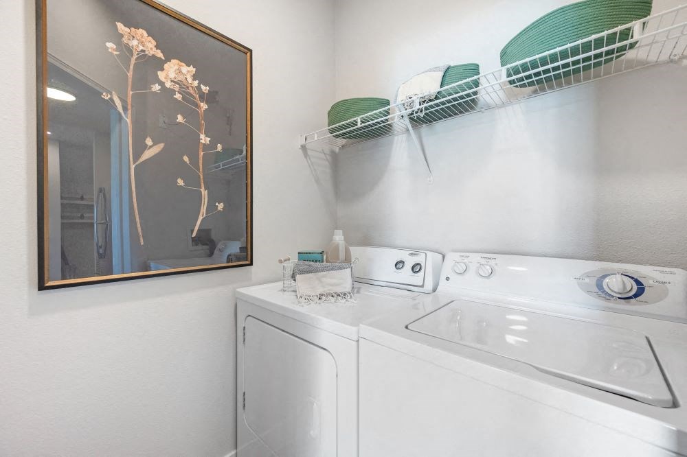 A white washing machine and dryer in a laundry room.