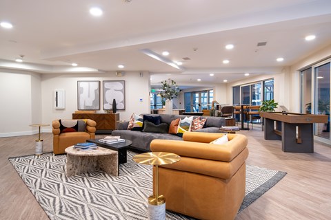 A living room with a patterned rug and a coffee table with a glass top.