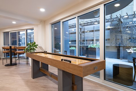 A pool table in a room with a view of the outside.