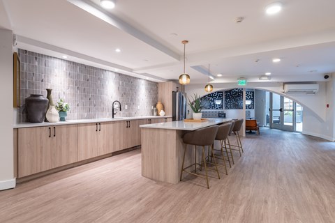 A modern kitchen with wooden floors and a central island.