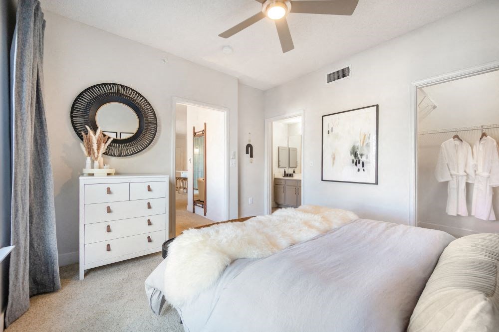 A bedroom with a large bed and a dresser.
