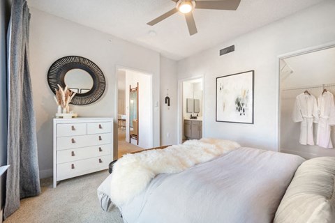 A bedroom with a large bed and a dresser.