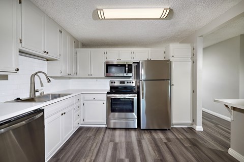 A kitchen with white cabinets and stainless steel appliances.