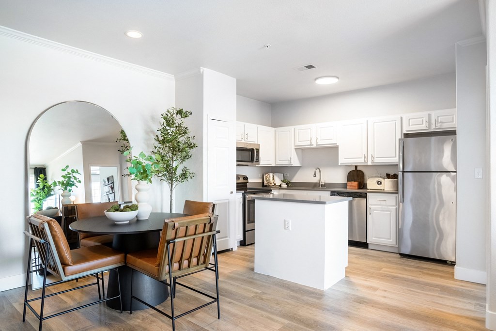 A modern kitchen with a dining table and chairs. at The Viridian Apartments, Greenwood Village 80111