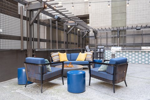 A patio with blue furniture and a fire pit.