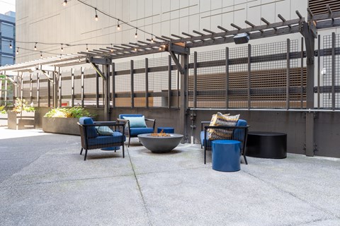 A patio with a table, chairs and a planter.