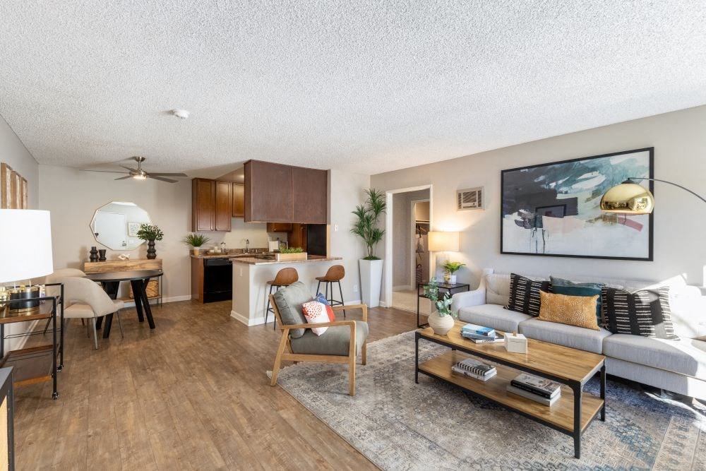 A living room with a white couch, a wooden coffee table, and a painting on the wall.
