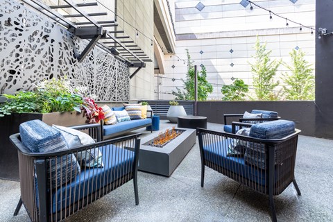 A modern outdoor seating area with a black metal frame and blue cushions.