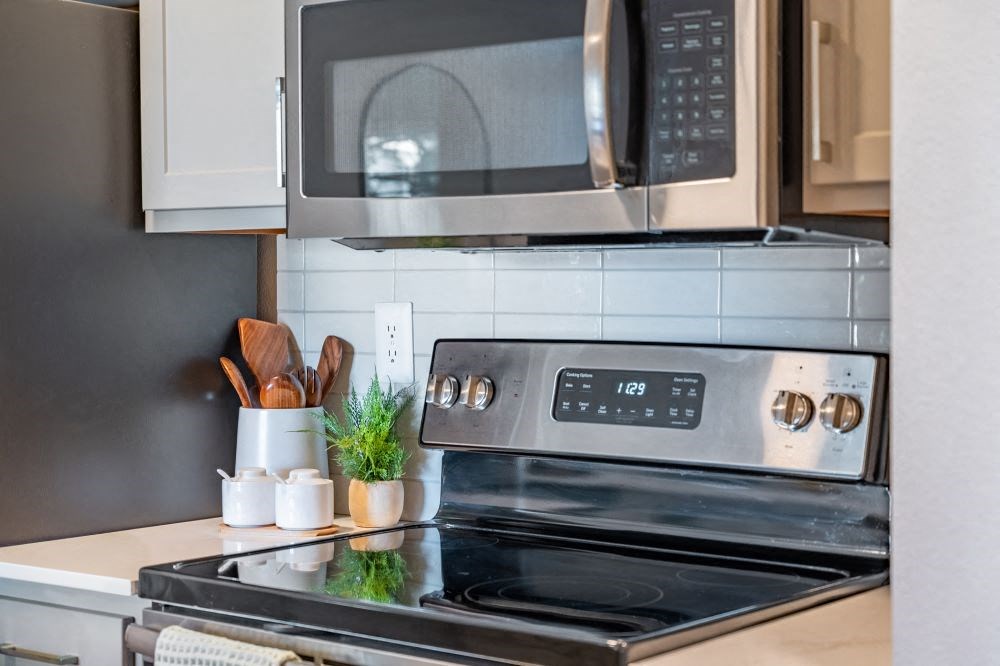 A modern kitchen with a stove, microwave, and oven.