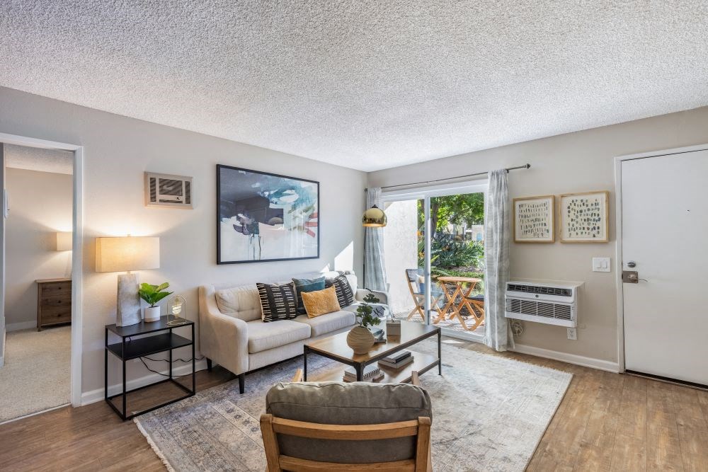 A living room with a couch, chair, and a painting on the wall.