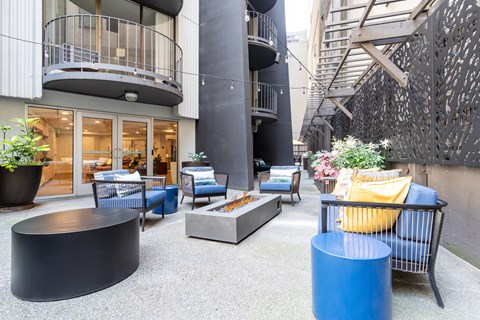 A modern outdoor seating area with blue and yellow cushions.