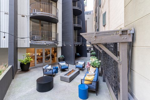 A patio area with a black table and blue chairs.