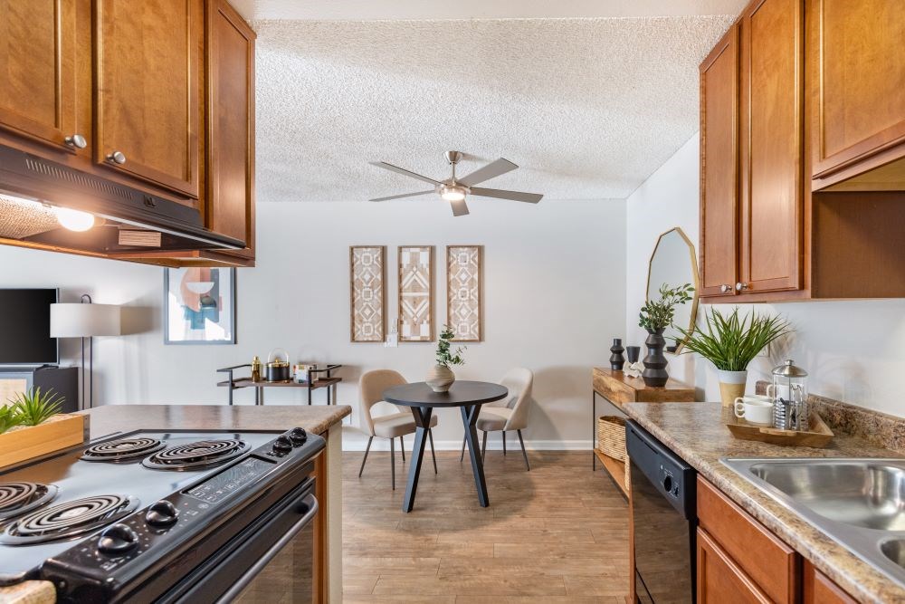A kitchen with a black stove top oven and wooden cabinets.